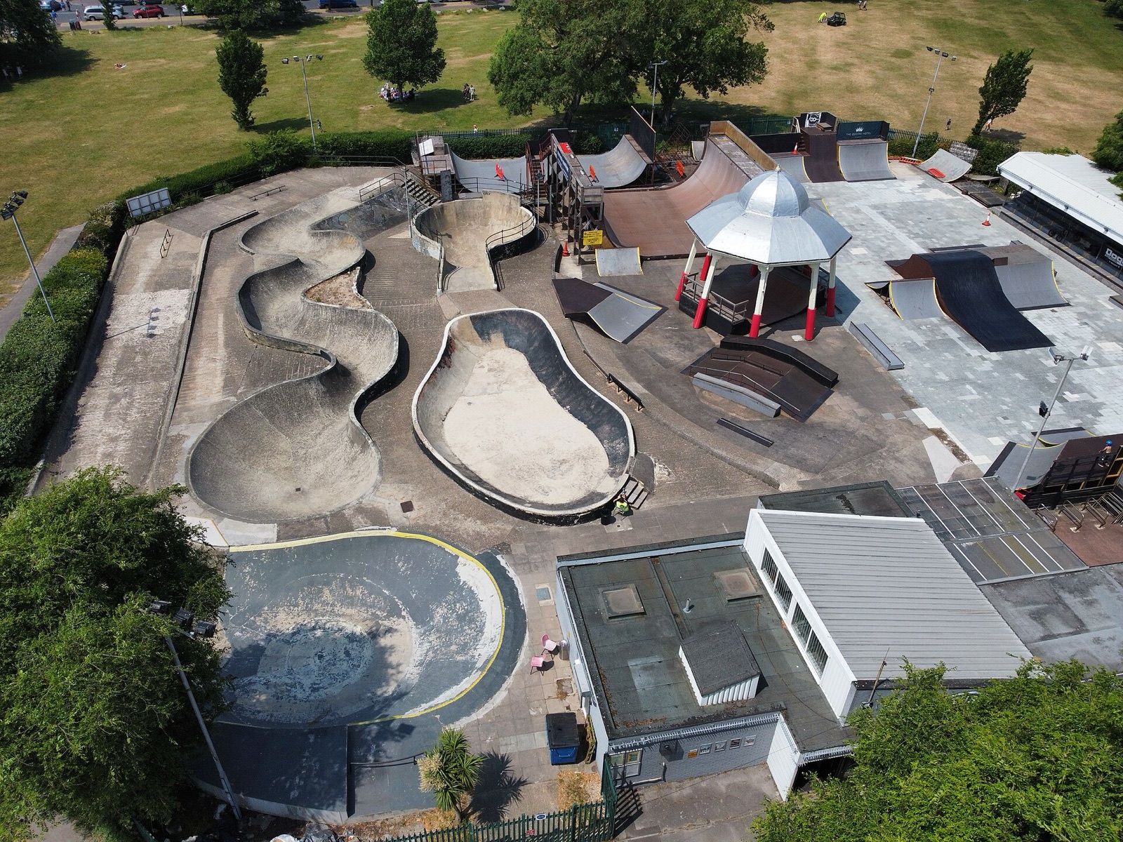 An aerial view of Southsea Skatepark, a large concrete park with snake runs, bowls and ramps set among trees.
